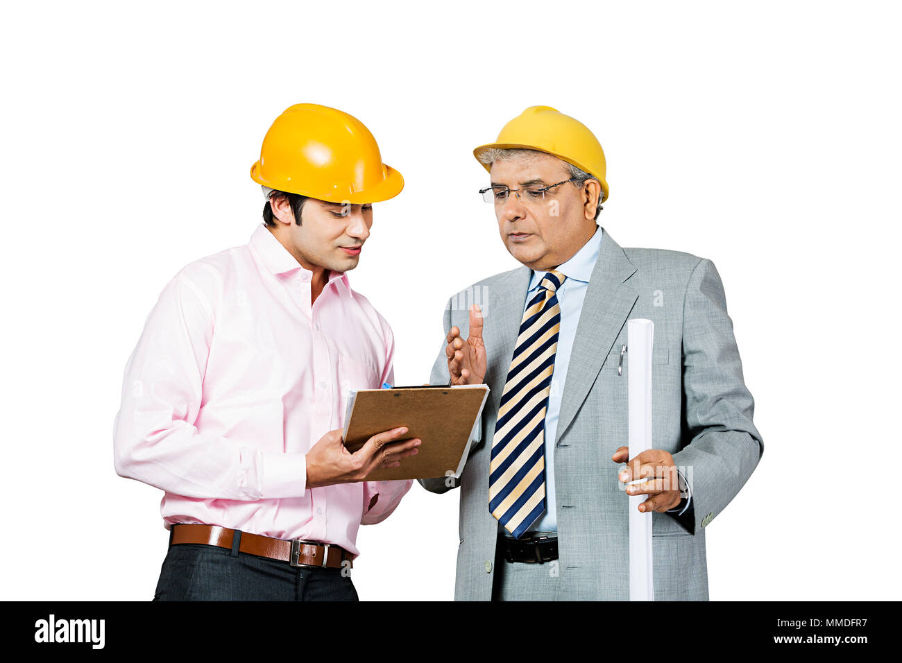 Two Male Architects with blueprint and clipboard working at Construction -site Stock Photo