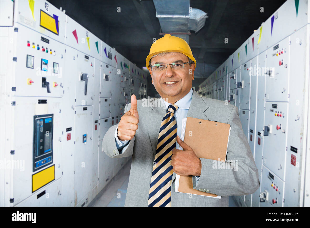 One Man supervisor holding clipboard Showing Thumbs-up Near Machine In Factory- Industry Stock Photo