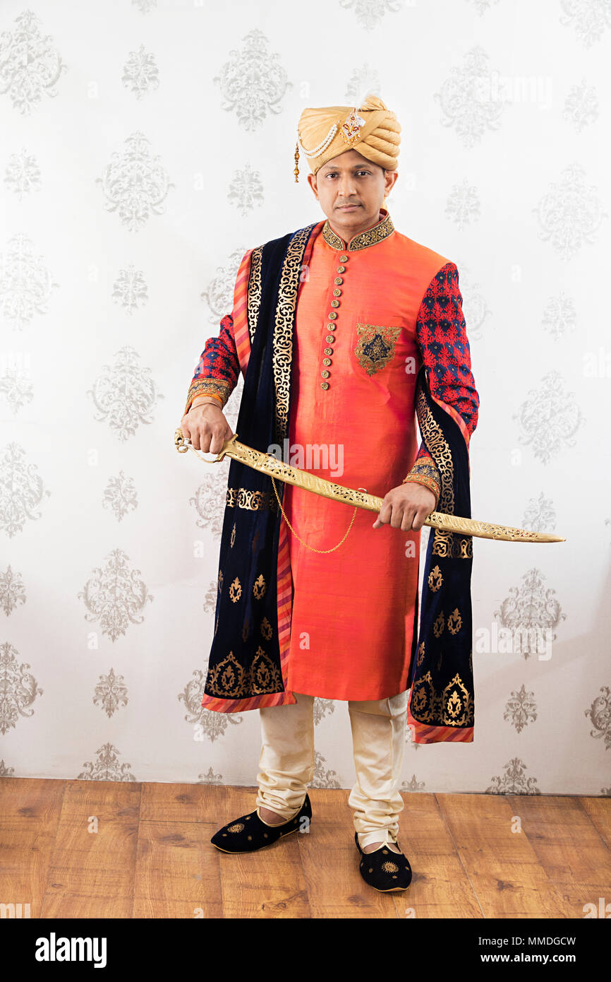 One Royalty Punjabi Groom Man Wearing Traditional Sherwani With Sword Stock Photo