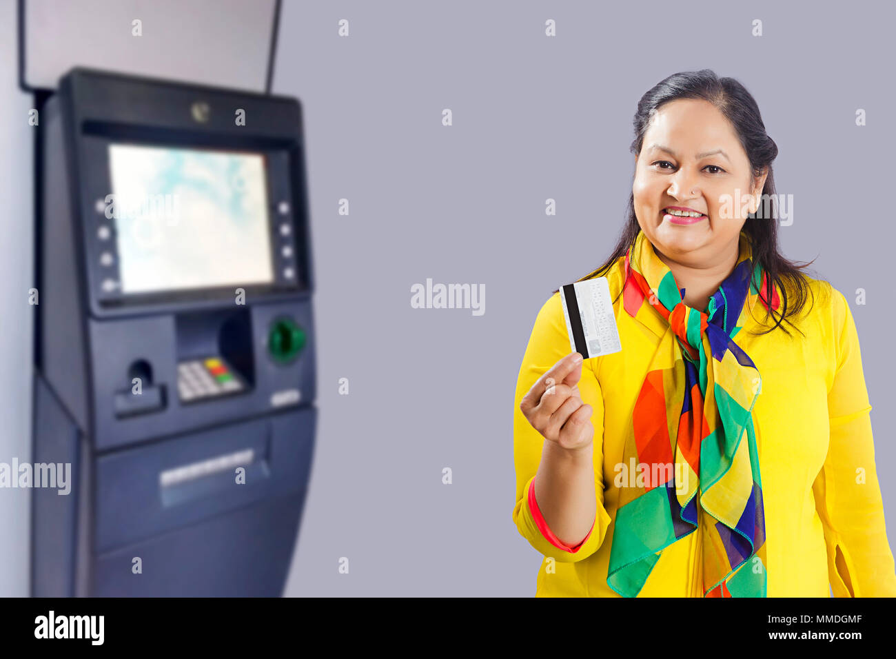 One Old Woman withdrawing Cash from Debit-card at ATM Machine Stock Photo