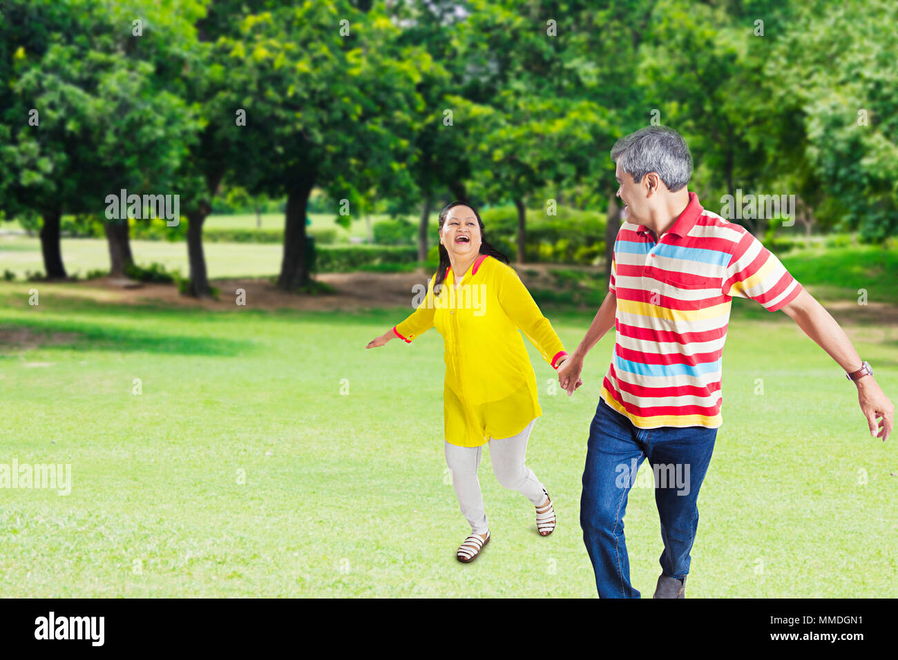 Two Senior Couple Hands Holding Running Together Fun Cheerful Garden Stock Photo