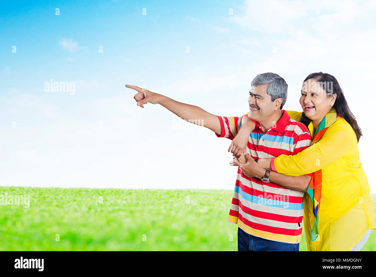 Senior Couple Pointing Finger Showing Happy Fun Cheerful In-Park Stock Photo