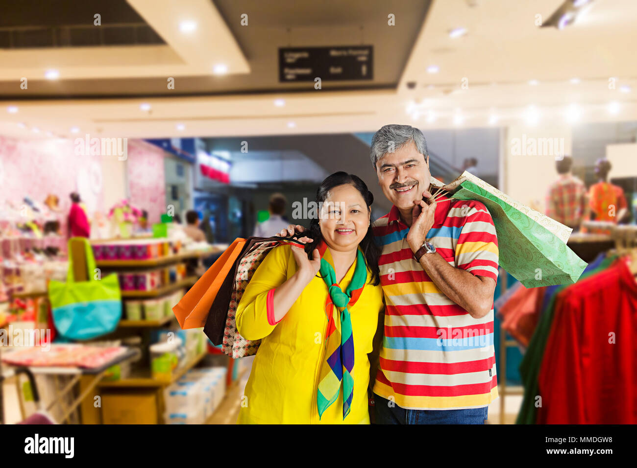 Happy Senior Couple Together Carrying Shopping Bags in Big-Bazaar Market Stock Photo