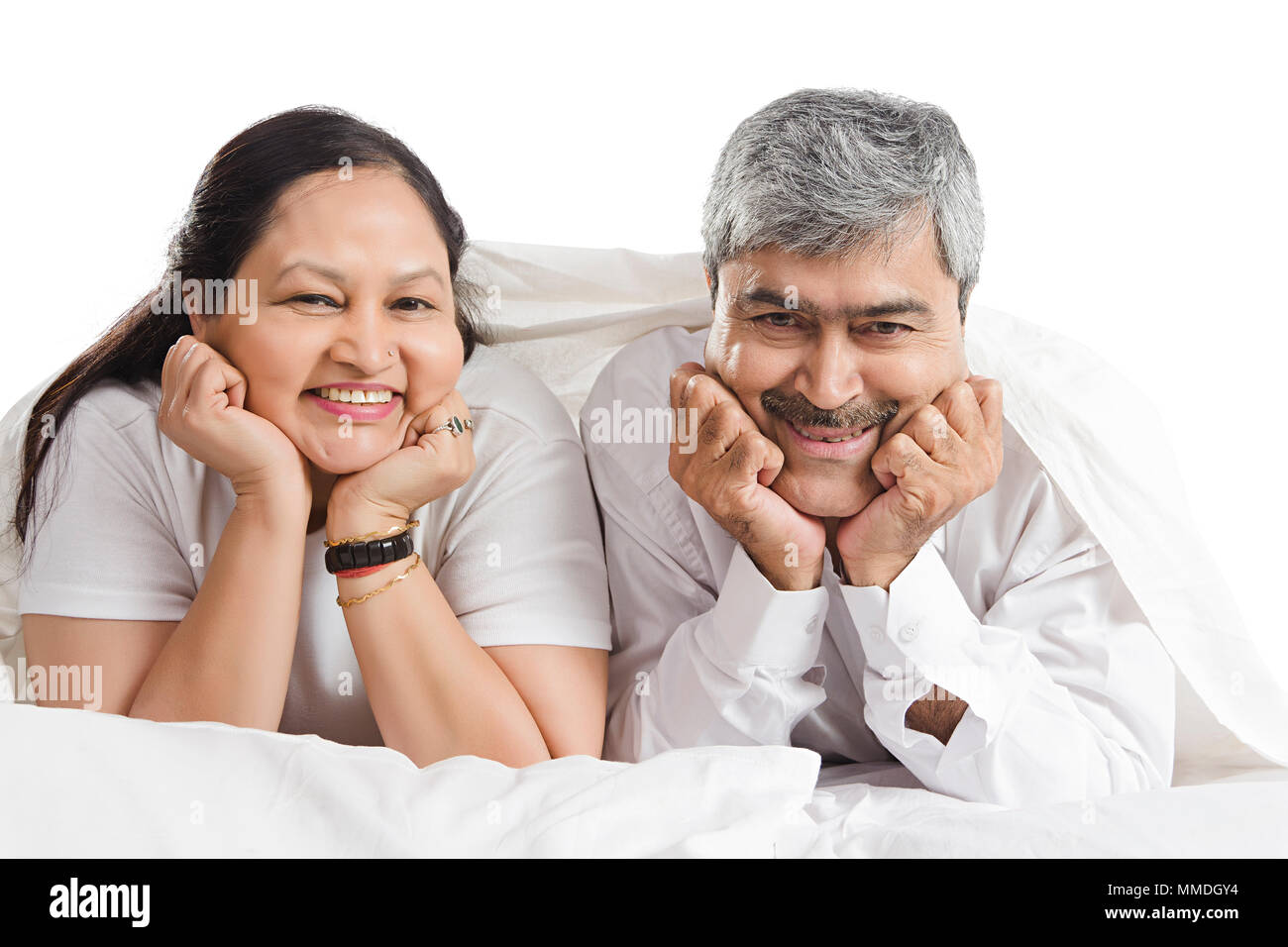 Happy Senior Couple Together Lying On Bed Relaxing Bedroom At-Home Stock Photo