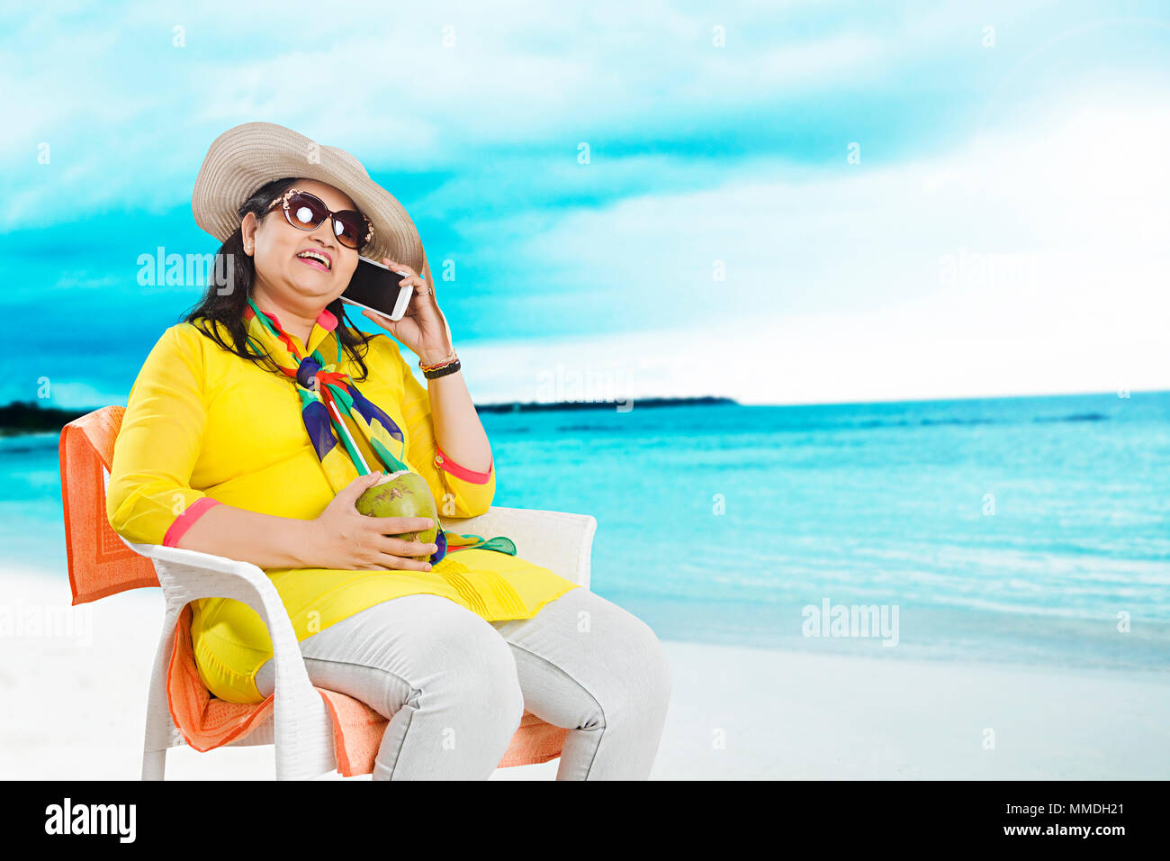 One Senior Woman Sitting Chair Talking Cellphone With Coconut -Water In-Beach Enjoy Stock Photo
