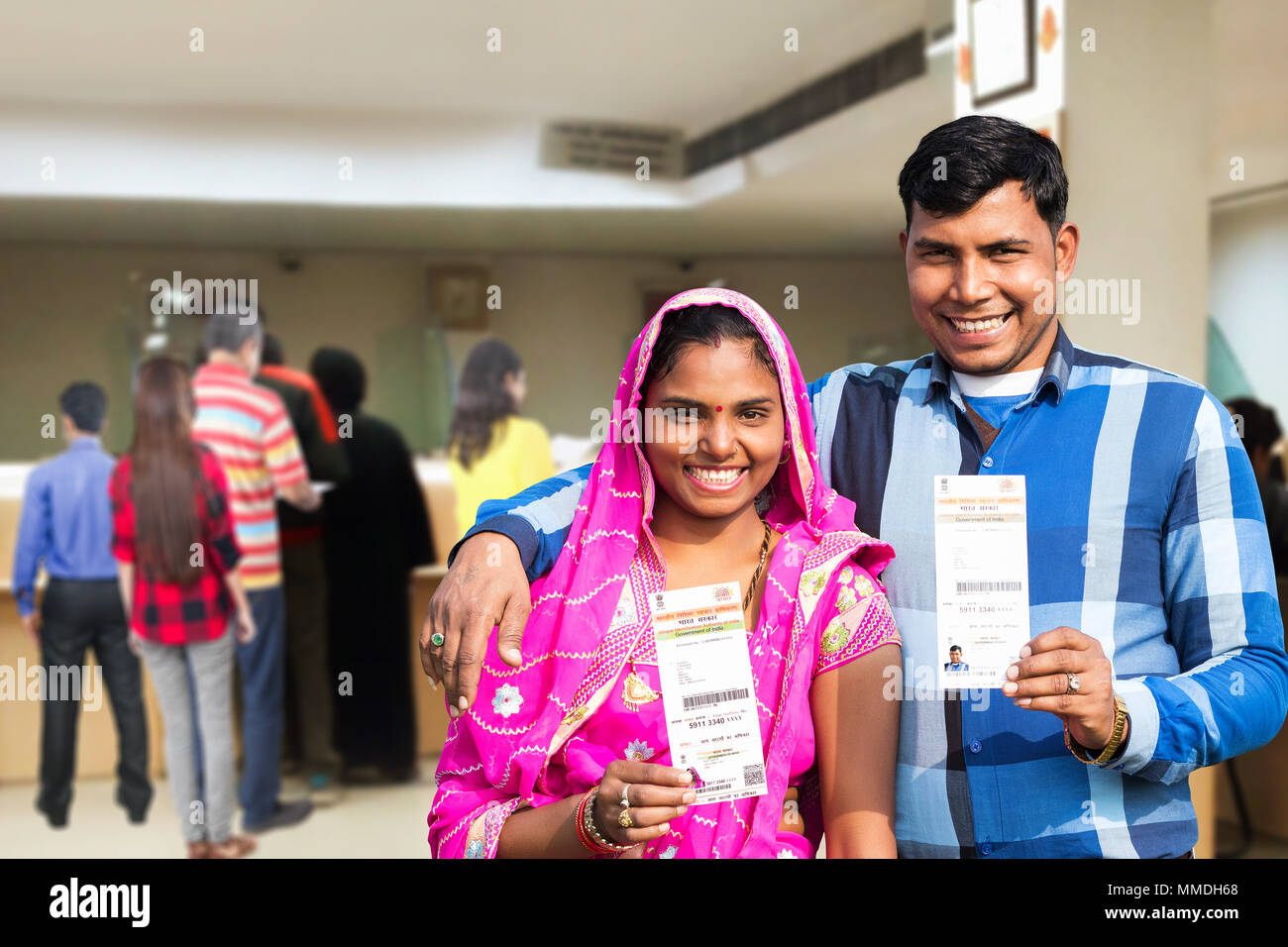 two villager couple showing aadhaar card government identity at bank MMDH68