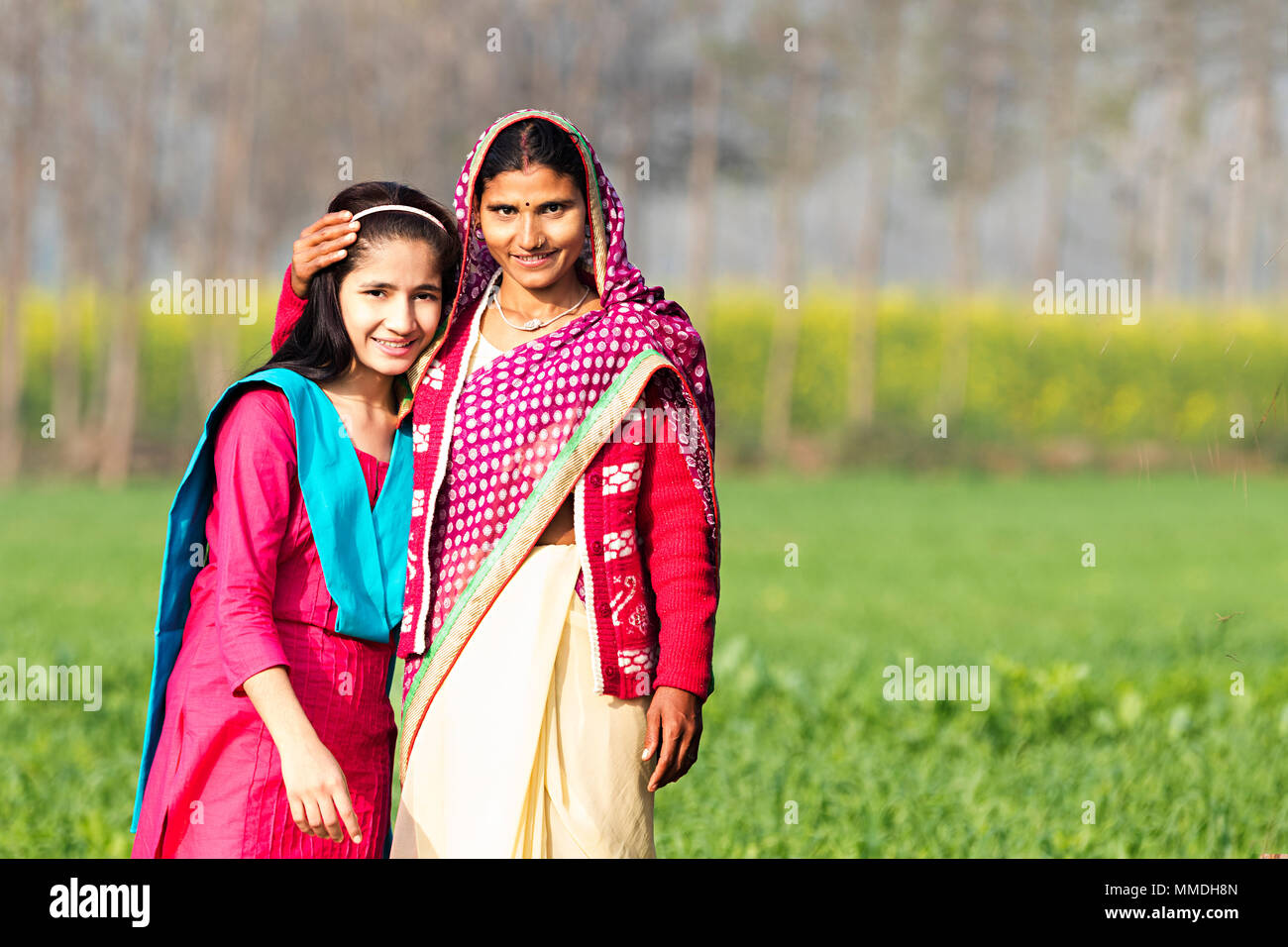 Smiling Caring Rural Mother And Teenage Girl Standing In-Farm Village Stock Photo