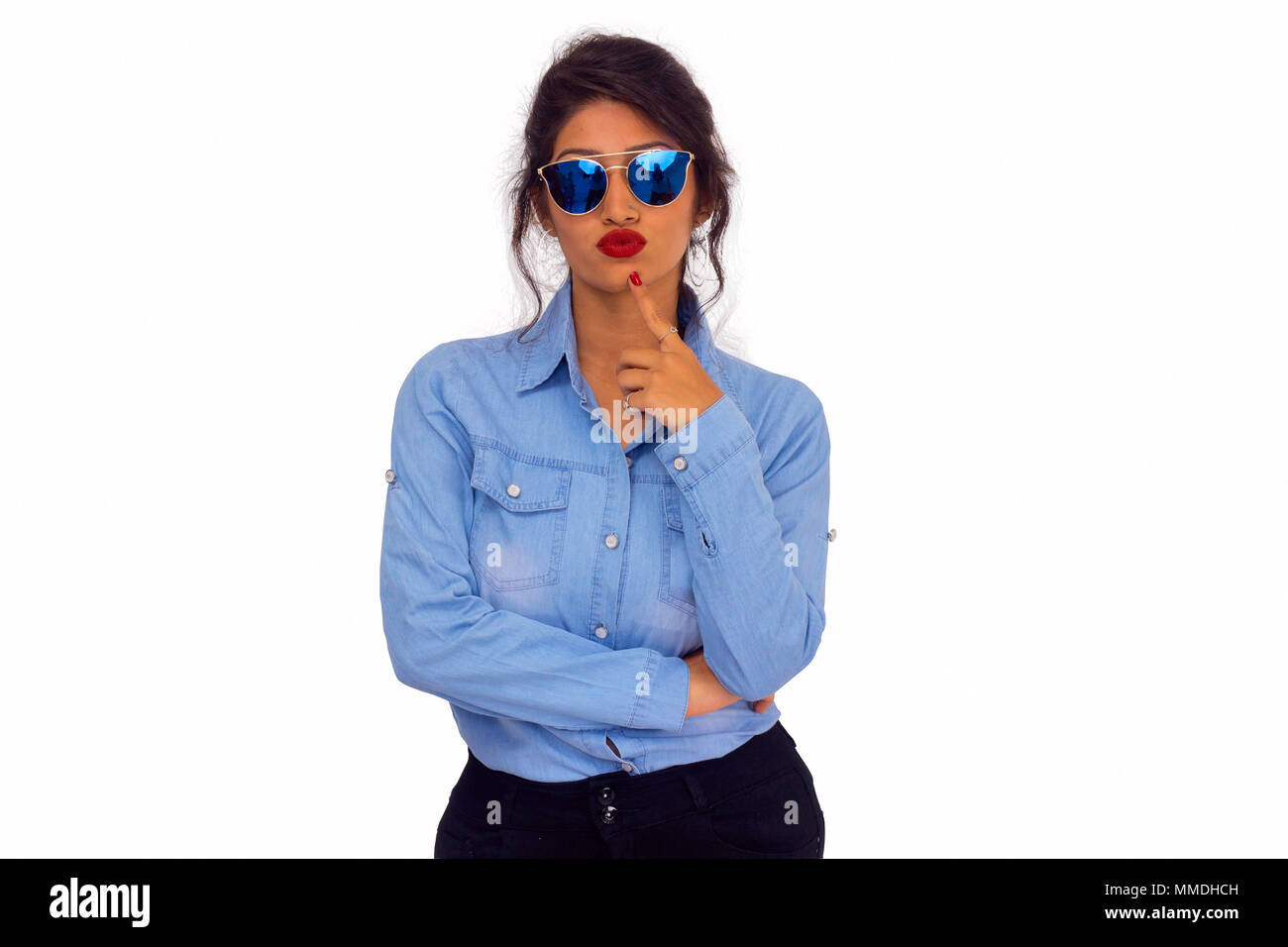 Stylish woman in blue top, wearing goggles with lips pursed and ...