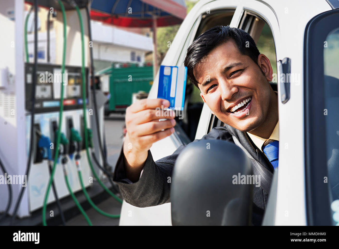 One Man Sitting Car showing Debit-card make payment at Petrol-pump Stock Photo