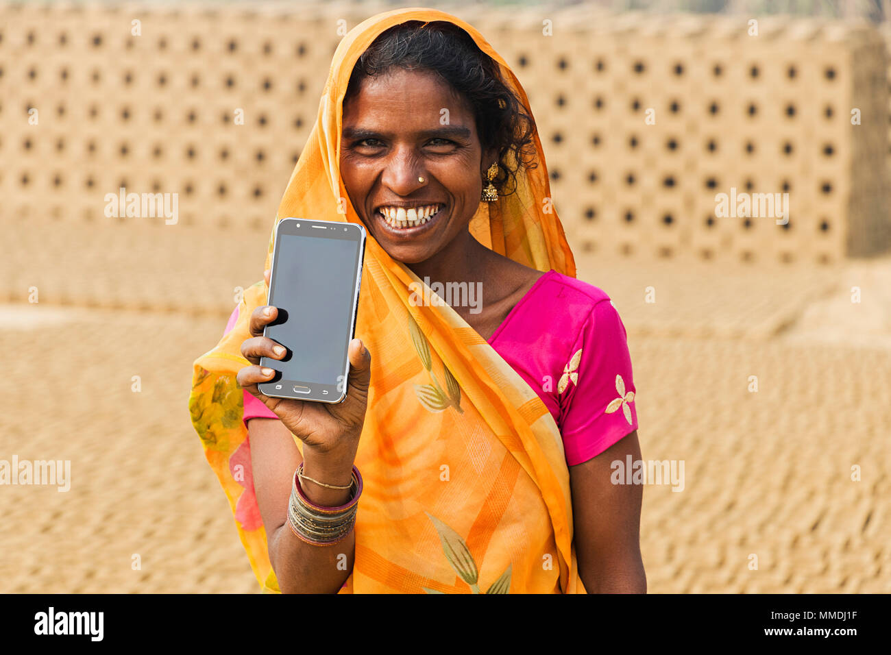 One Rural Female Factory Worker Showing Smartphone In-Brick Factory Village Stock Photo