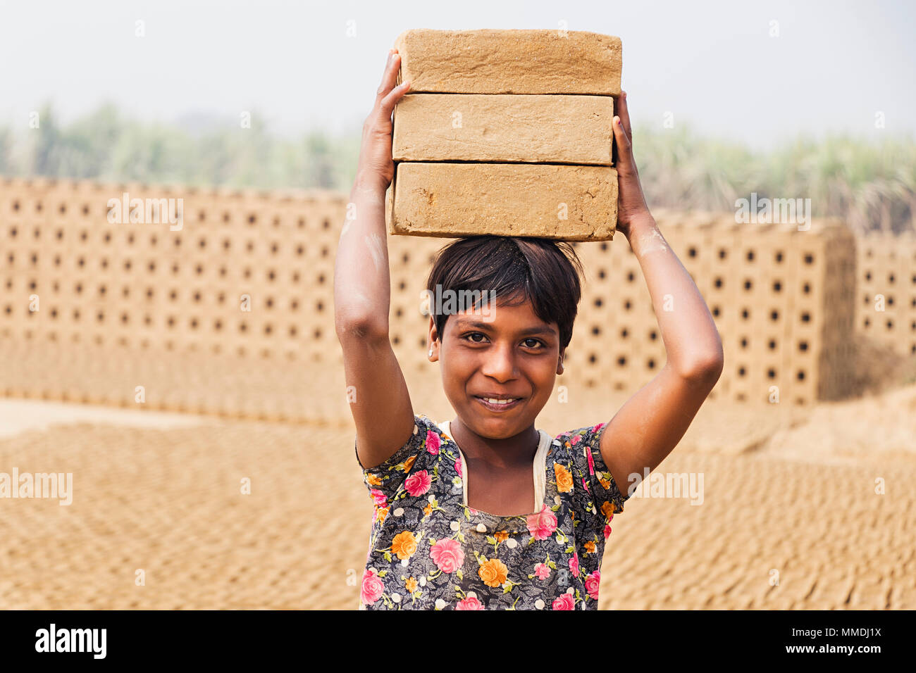 Rural Teenage Girl carrying stack bricks on his head Working Brick
