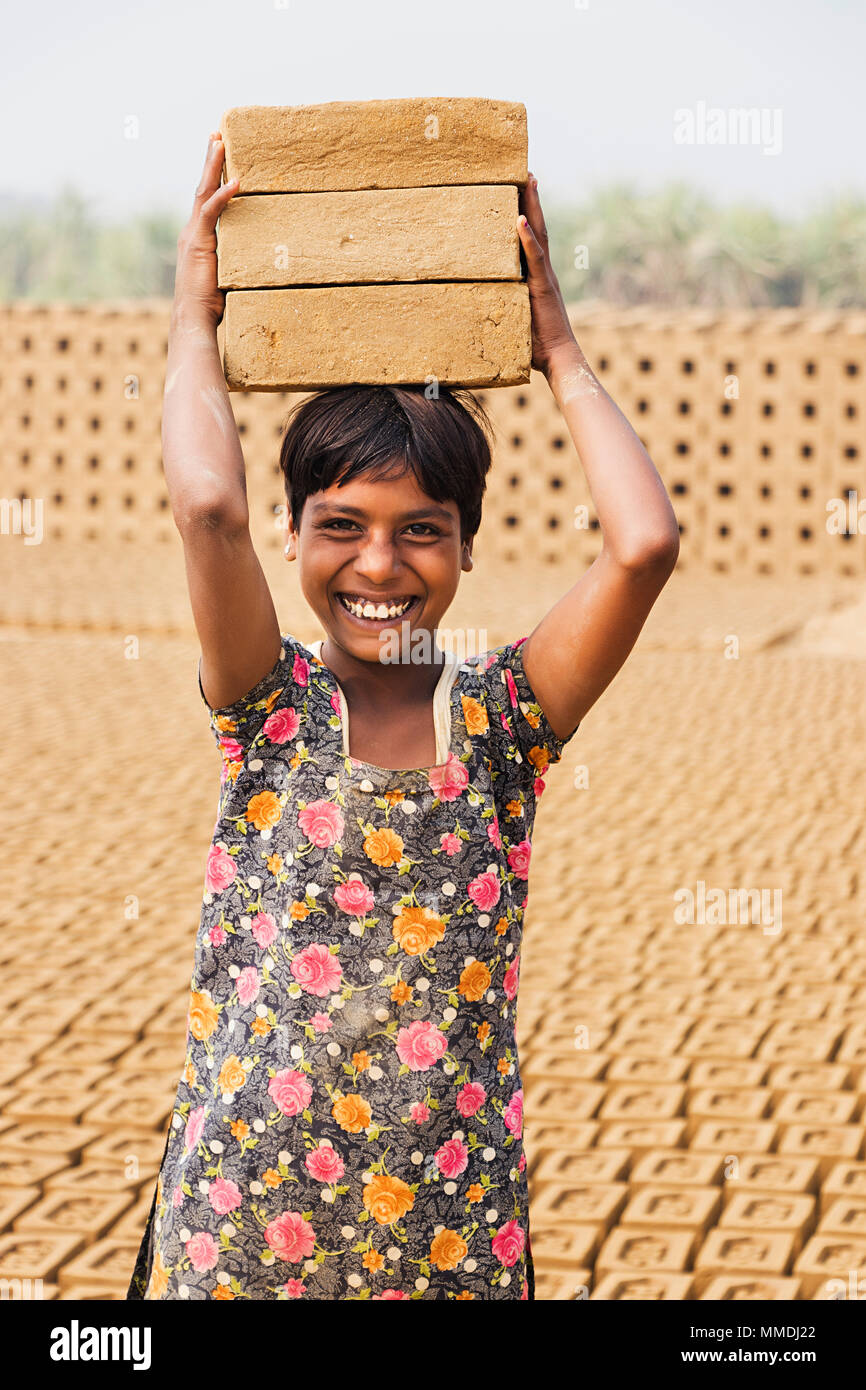 One Little Girl Carrying stacks Bicks on his head Working Brick -Factory Stock Photo