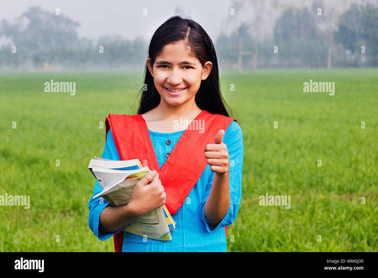 One Villager Girl College Student Showing Thumbs-up With Books Farm Stock Photo