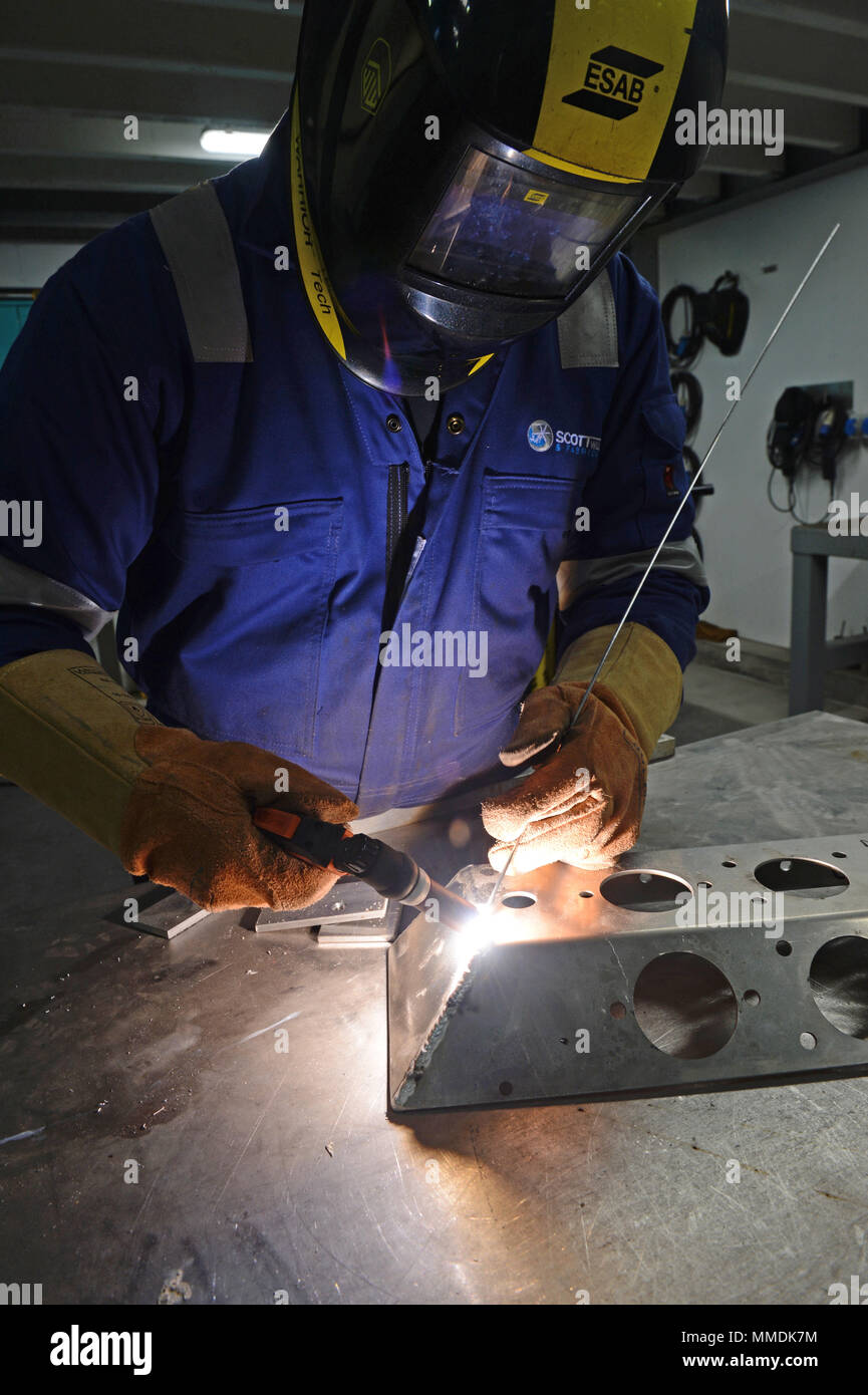 Welder welding together some stainless steel with a mig welder Stock Photo