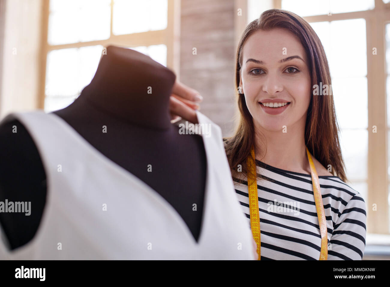 Optimistic female dressmaker designing dress Stock Photo