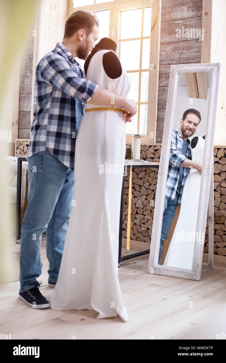 Handsome male couturier fixing dress size Stock Photo