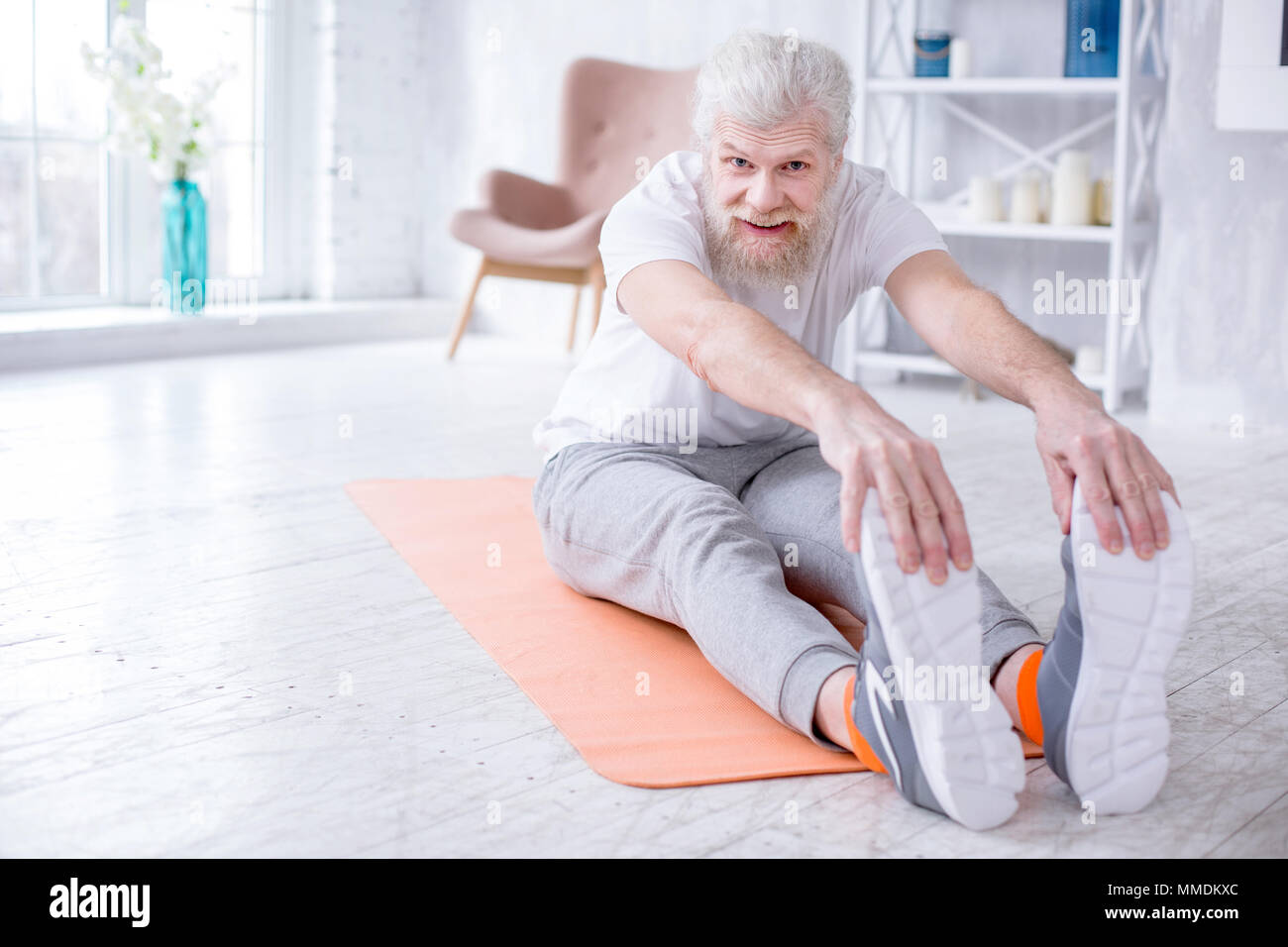 Handsome elderly man bending forward and touching toes Stock Photo Alamy