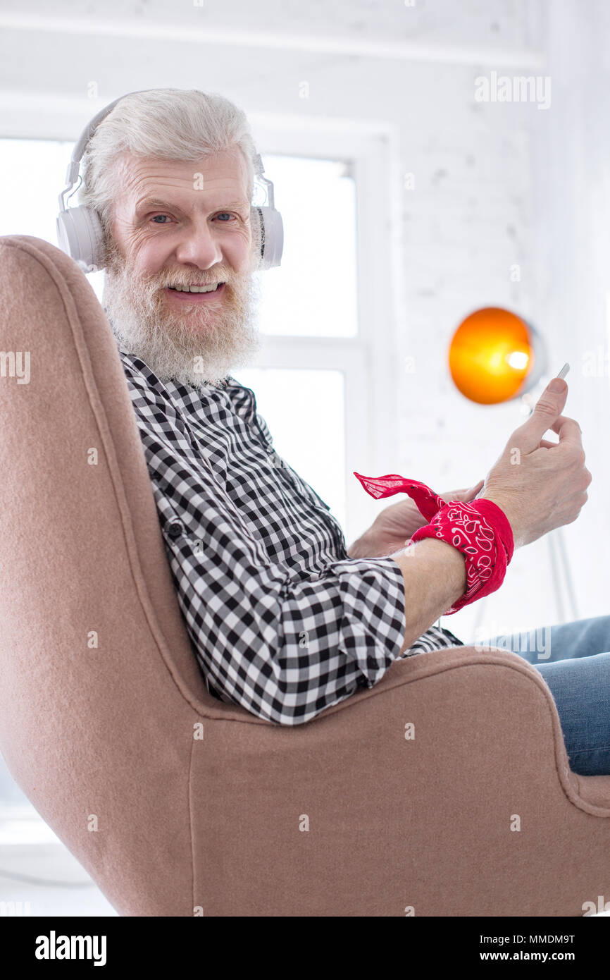 Charming elderly man posing while using tablet Stock Photo