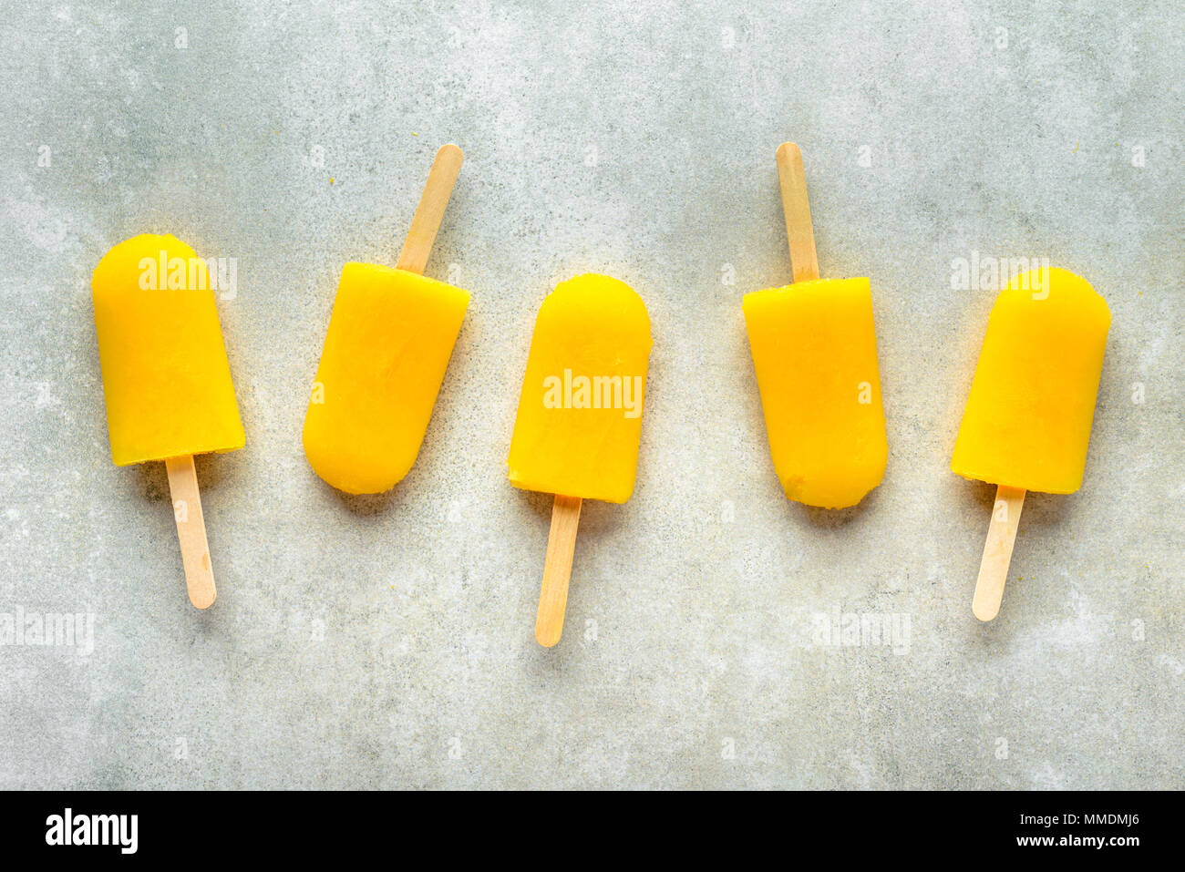 Homemade popsicles with orange juice, ice lollies on sticks, top view