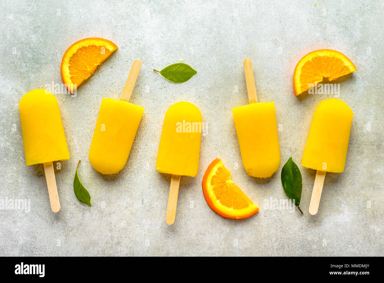Homemade popsicles with orange juice, ice lollies on sticks, top view