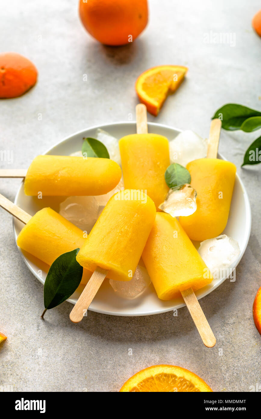 Homemade popsicles with orange juice, ice lollies on sticks Stock Photo