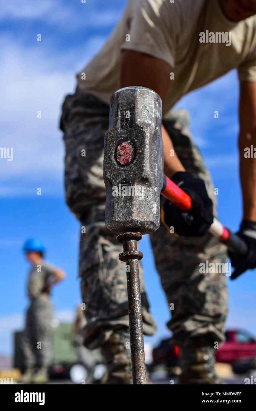 A 99th Civil Engineer Squadron structural engineer drives a stake into