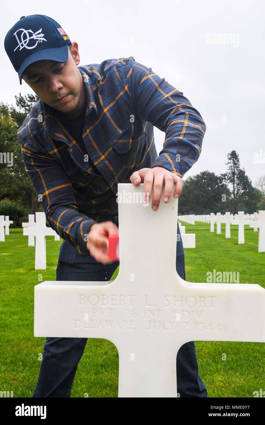 171019-N-FP878-068 NORMANDY, France (Oct. 19, 2017) Culinary Specialist 2nd Class Julian Fuenzalida, from Virginia Beach, Va., assigned to the Arleigh Burke-class guided-missile destroyer USS Donald Cook (DDG 75) cleans a headstone at the Normandy American Cemetery during a community relations project Oct. 19, 2017.  Donald Cook, forward-deployed to Rota, Spain, is on its sixth patrol in the U.S. 6th Fleet area of operations in support of regional allies and partners, and U.S. national security interests in Europe. (U.S. Navy photo by Mass Communication Specialist 1st Class Theron J. Godbold / Stock Photo
