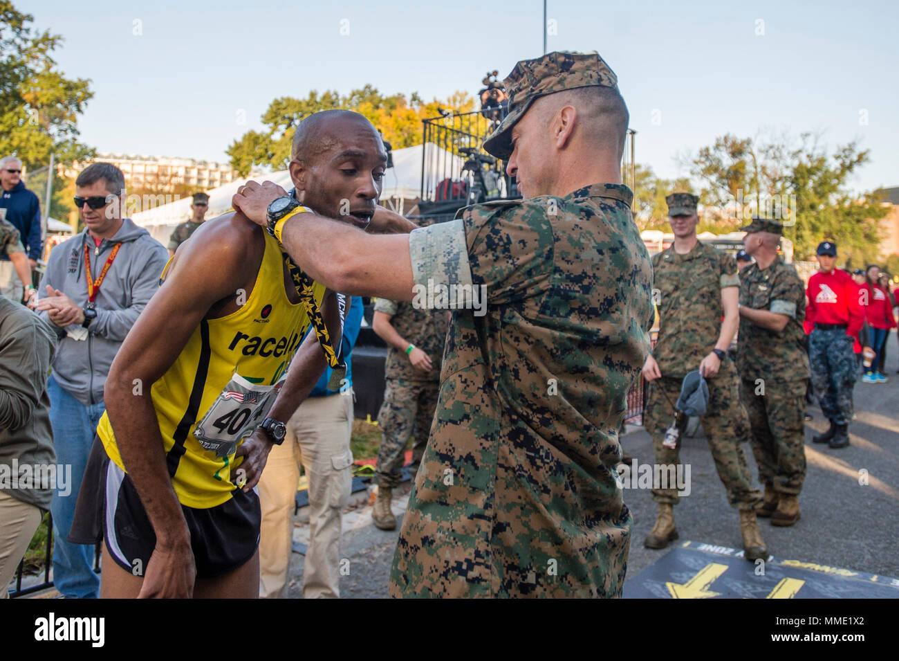 U.S. Marine Corps Col. Joseph Murray, commanding officer of Marine Corps Base Quantico, presents a finisher medal to Denzel Ramirez, Arlington, Va., first finisher of the Marine Corps Marathon 10K, Arlington, Va., Oct. 22, 2017. Also known as 'The People's Marathon,' the 26.2 mile race drew roughly 30,000 participants to promote physical fitness, generate goodwill in the community, and showcase the organizational skills of the Marine Corps. (U.S. Marine Corps photo by Lance Cpl. Yasmin D. Perez) Stock Photo