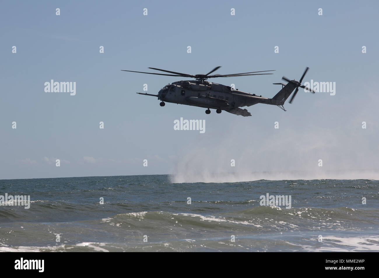 A CH-53 Super Stallion hovers over the water during a helocast exercise at Marine Corps Base Camp Lejeune, N.C., Oct. 19, 2017. Bold Alligator 17 is a large-scale, multinational amphibious exercise designed to execute complex shaping operations, amphibious landing and attack, and sea basing operations to improve U.S. and coalition ship-to-shore capabilities. (U.S. Marine Corps photo by Lance Cpl. Ashley McLaughlin) Stock Photo