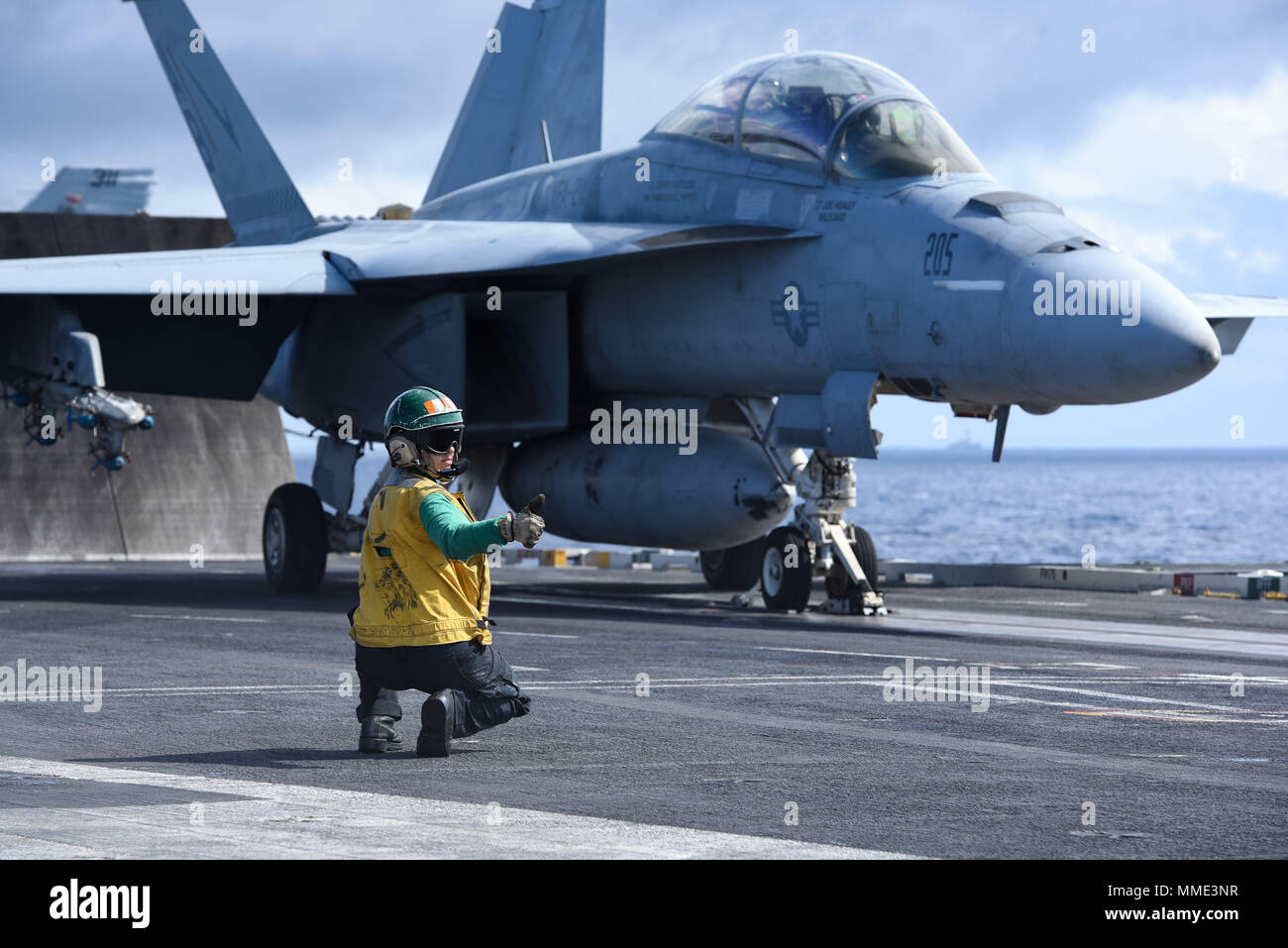 171024-N-PE636-005 ATLANTIC OCEAN (Oct. 24, 2017) Aviation Boatswain's Mate (Equipment) 3rd Class Nickolas Lim signals to launch an F/A-18F Super Hornet, assigned to the 'Fighting Checkmates' of Strike Fighter Squadron (VFA) 211, from the flight deck aboard USS Harry S. Truman (CVN 75). The ship is  underway conducting Tailored Shipboard Test Availability and Final Evaluation Problem in preparation for future operations. (U.S. Navy photo by Mass Communication Specialist 2nd Class Anthony Flynn/Released) Stock Photo