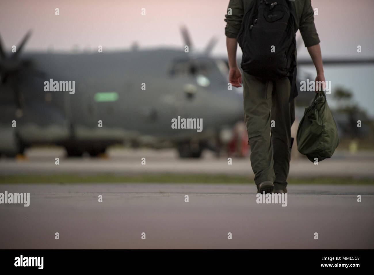An Airman from the 71st Rescue Squadron walks to an HC-130J Combat King ...