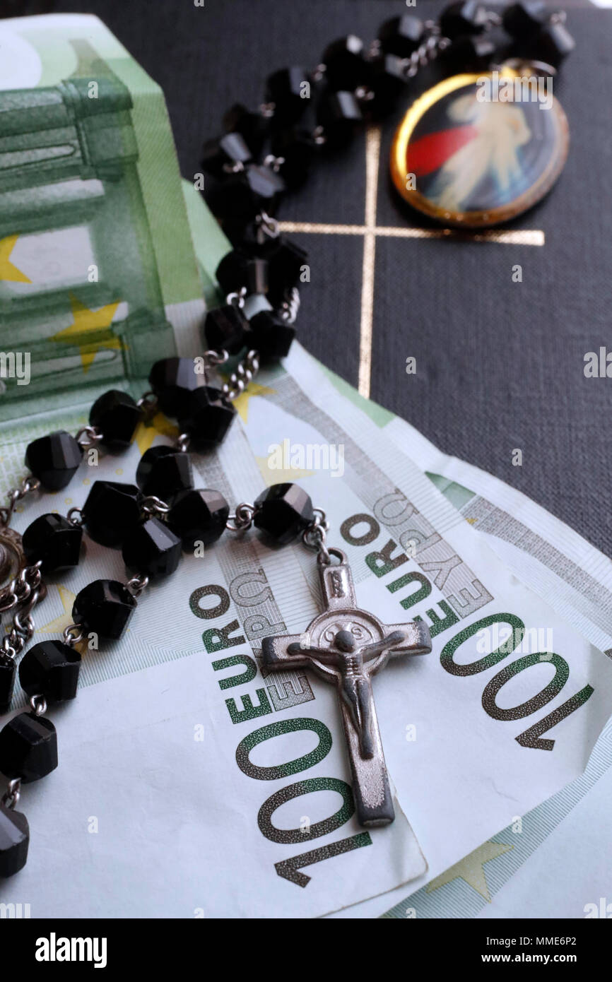 Money and religion. Prayer beads, bible and euros. Stock Photo