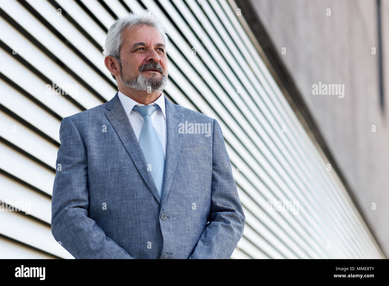 Portrait of a senior businessman with arms crossed outside of modern ...