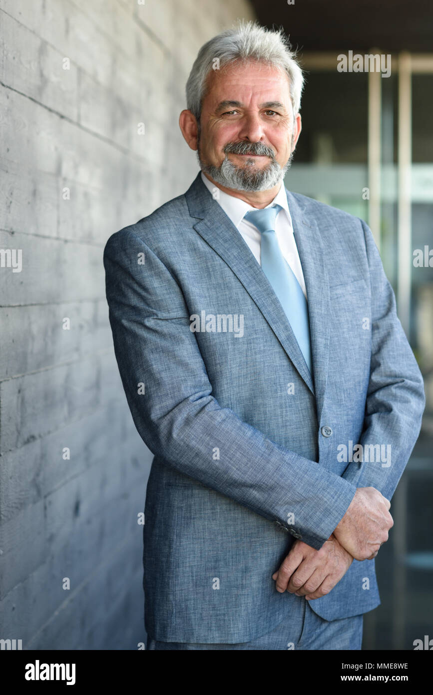 Portrait of a senior businessman with arms crossed outside of modern ...