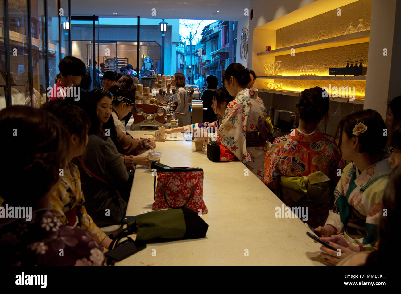 Japanese girls in traditional kimonos relaxing in a modern coffee shop