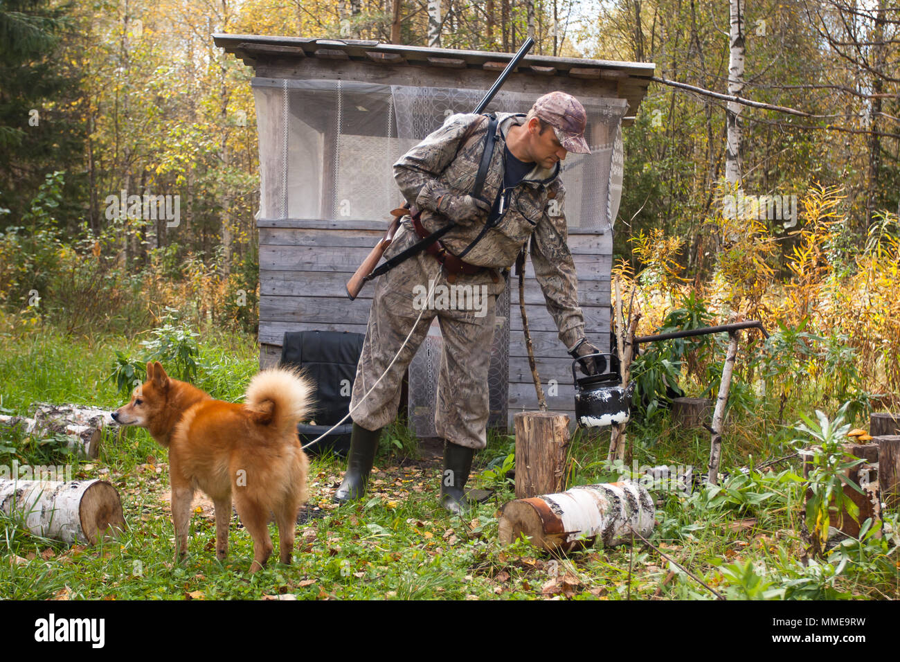 hunter with dog near the forest hut Stock Photo