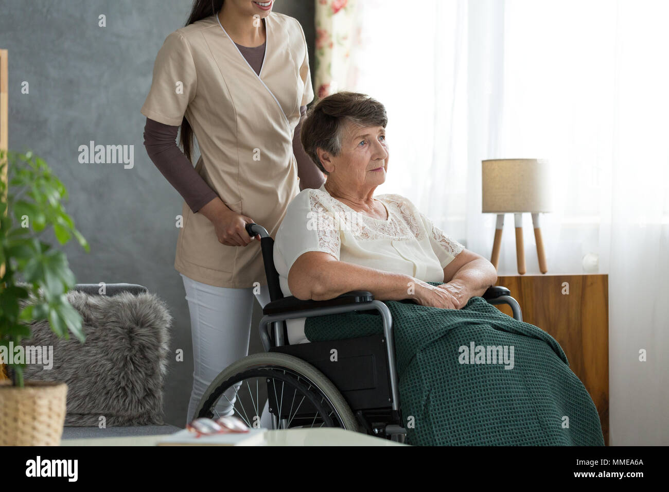 Senior lady with alzheimer's disease, sitting in a wheelchair, confused