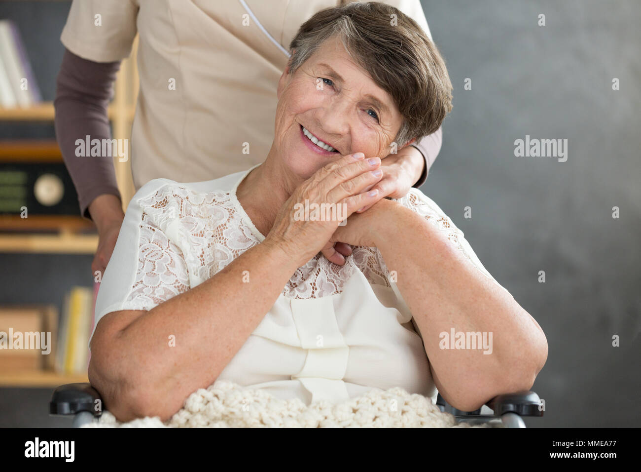 Close-up photo of smiling pensioner bonding with her caregiver. Elder support concept. Stock Photo
