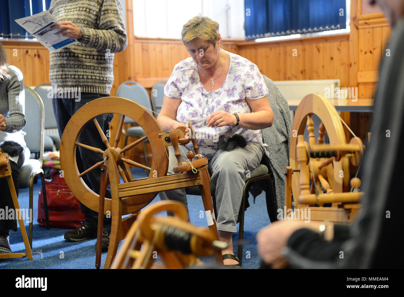 Spinners and weaver working on spinning wheels making yarn at the
