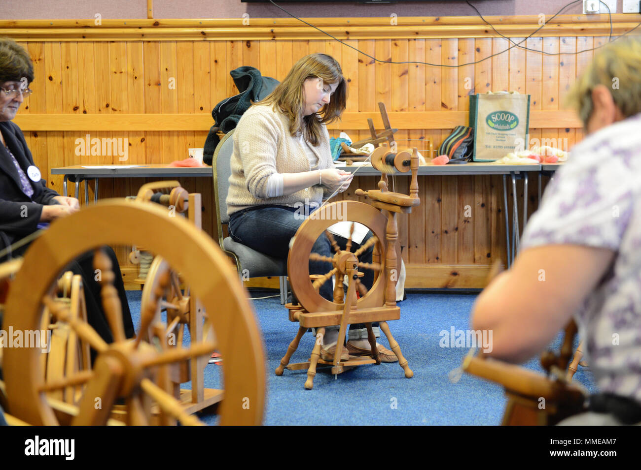 Spinners and weaver working on spinning wheels making yarn at the