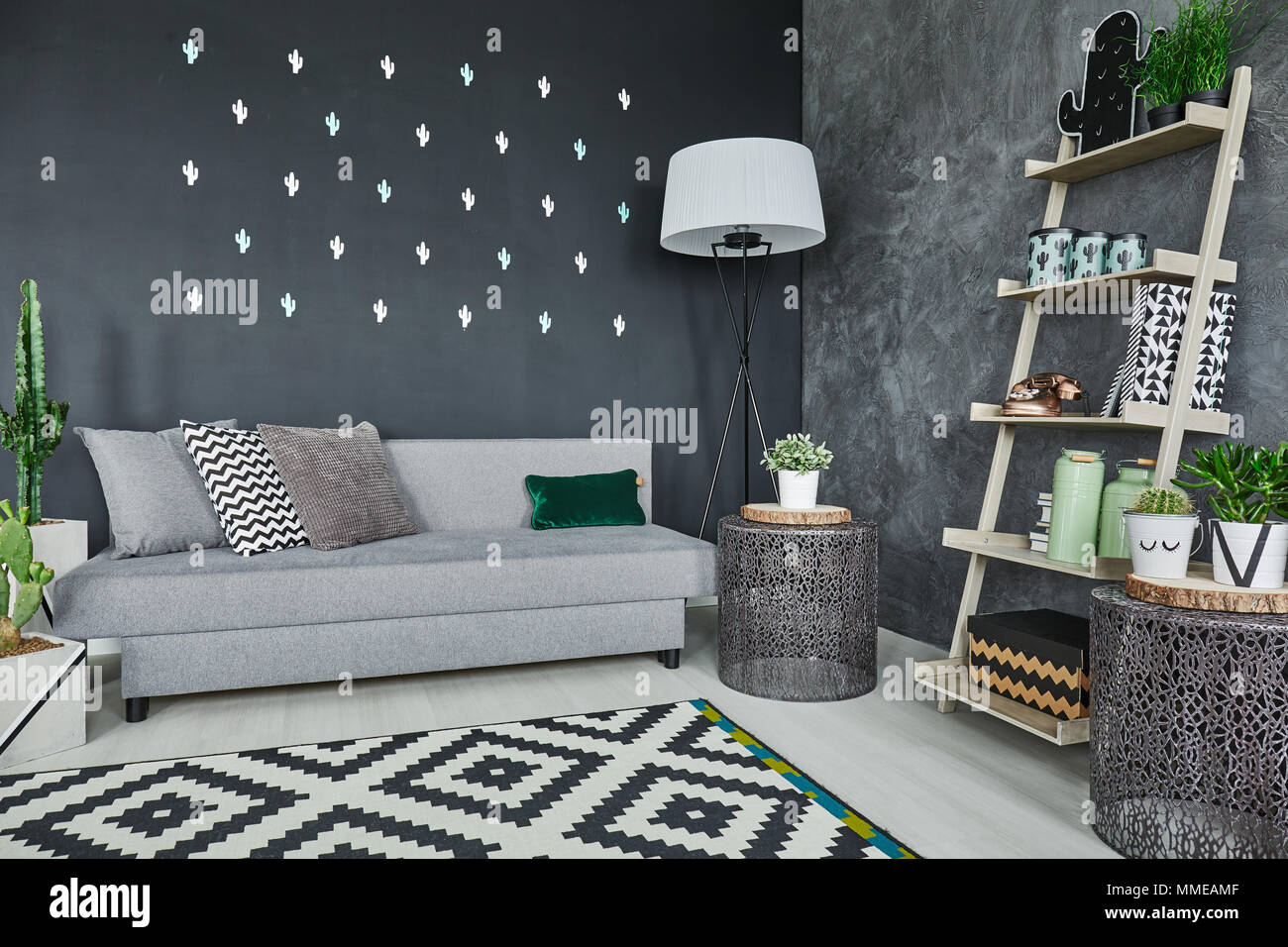 Room with black cactus wall decor and sofa Stock Photo - Alamy