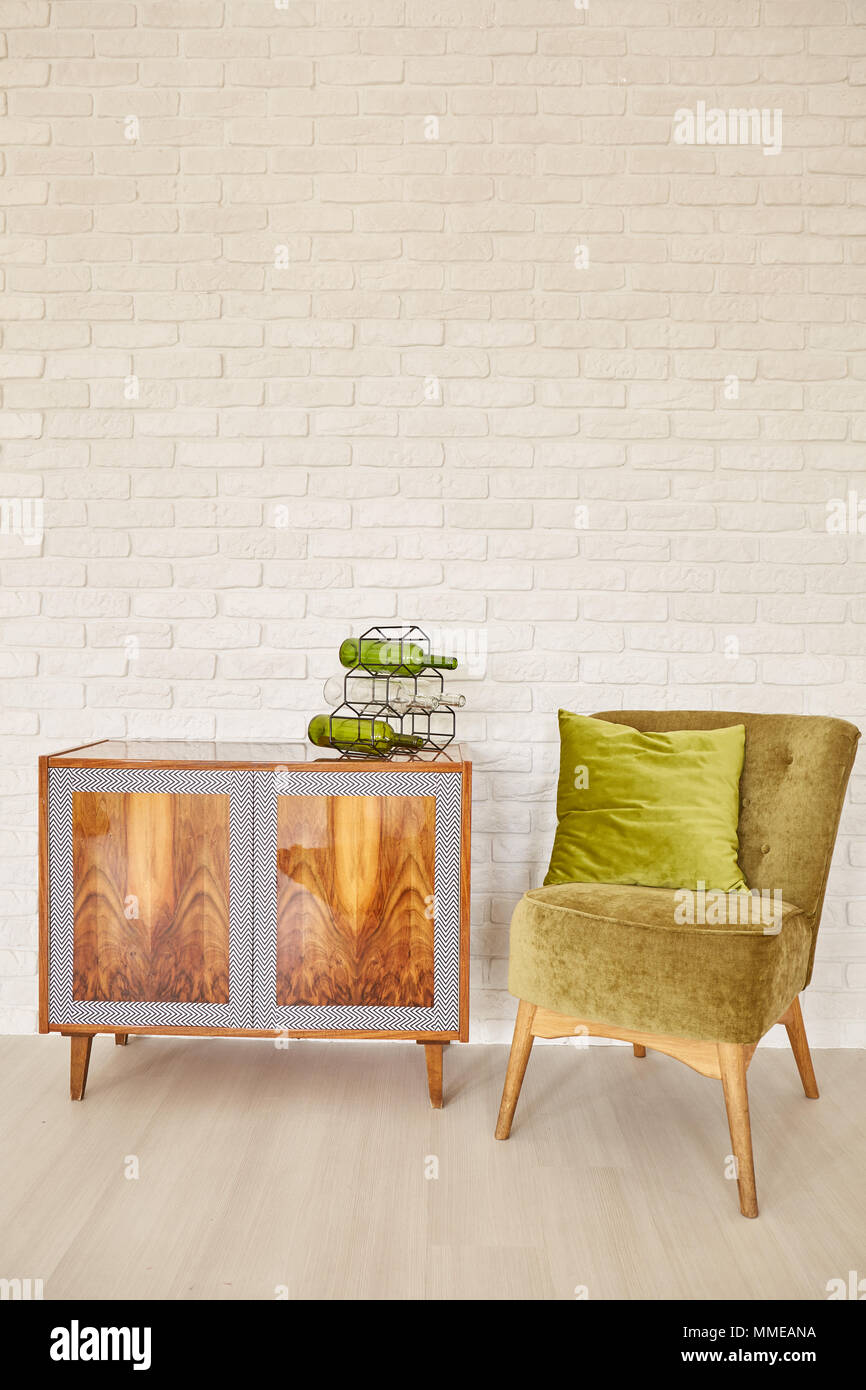 Interior With White Brick Wall Wooden Dresser And Green Armchair