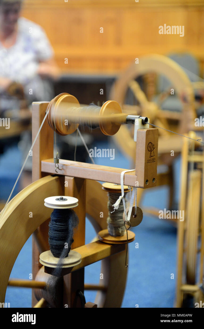 Spinners and weaver working on spinning wheels making yarn at the