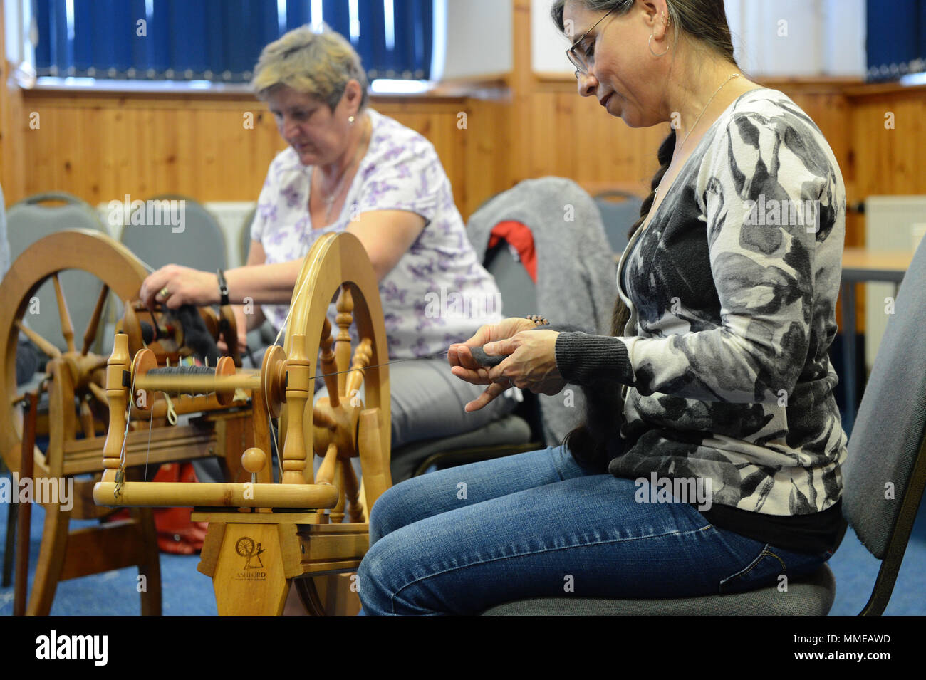 Spinners and weaver working on spinning wheels making yarn at the