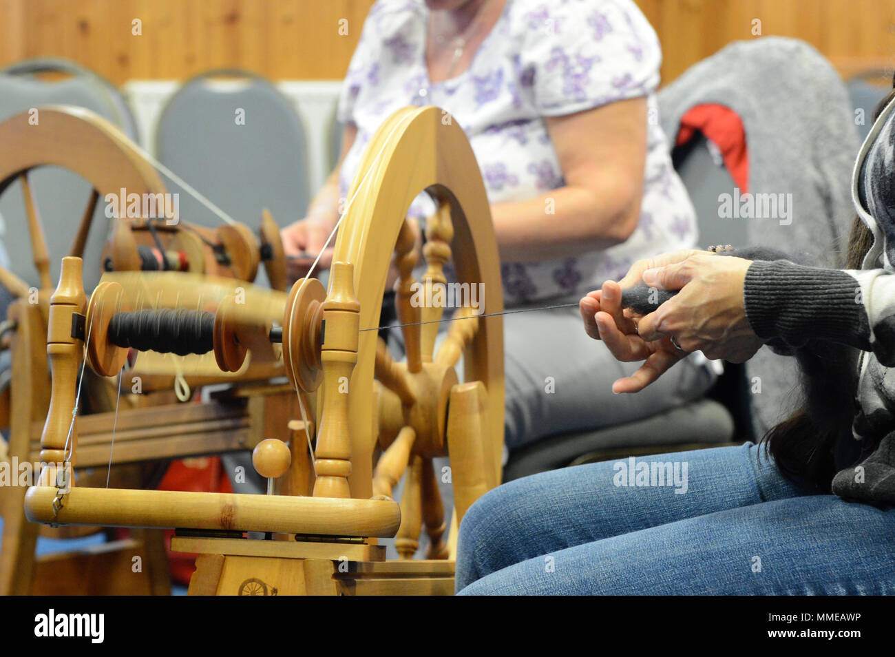 Spinners and weaver working on spinning wheels making yarn at the
