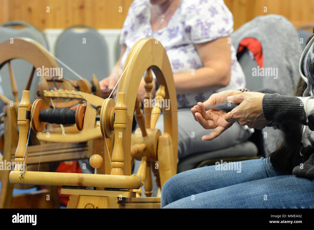 Spinners and weaver working on spinning wheels making yarn at the