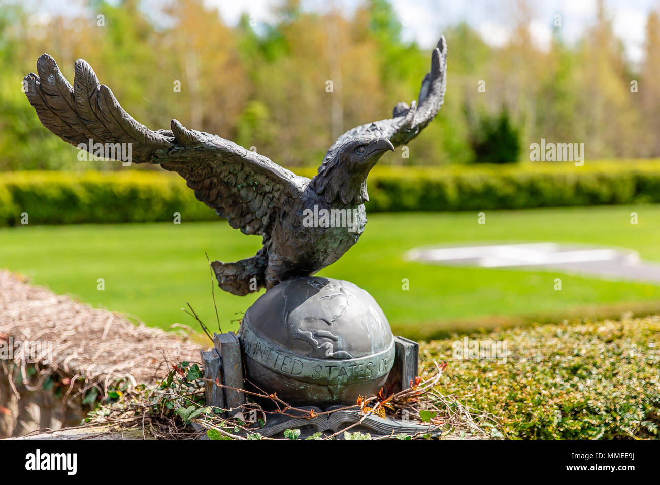 Sculpture of Eagle with spread wings sitting on a globe with North America continent. Helipad in the background. Stock Photo