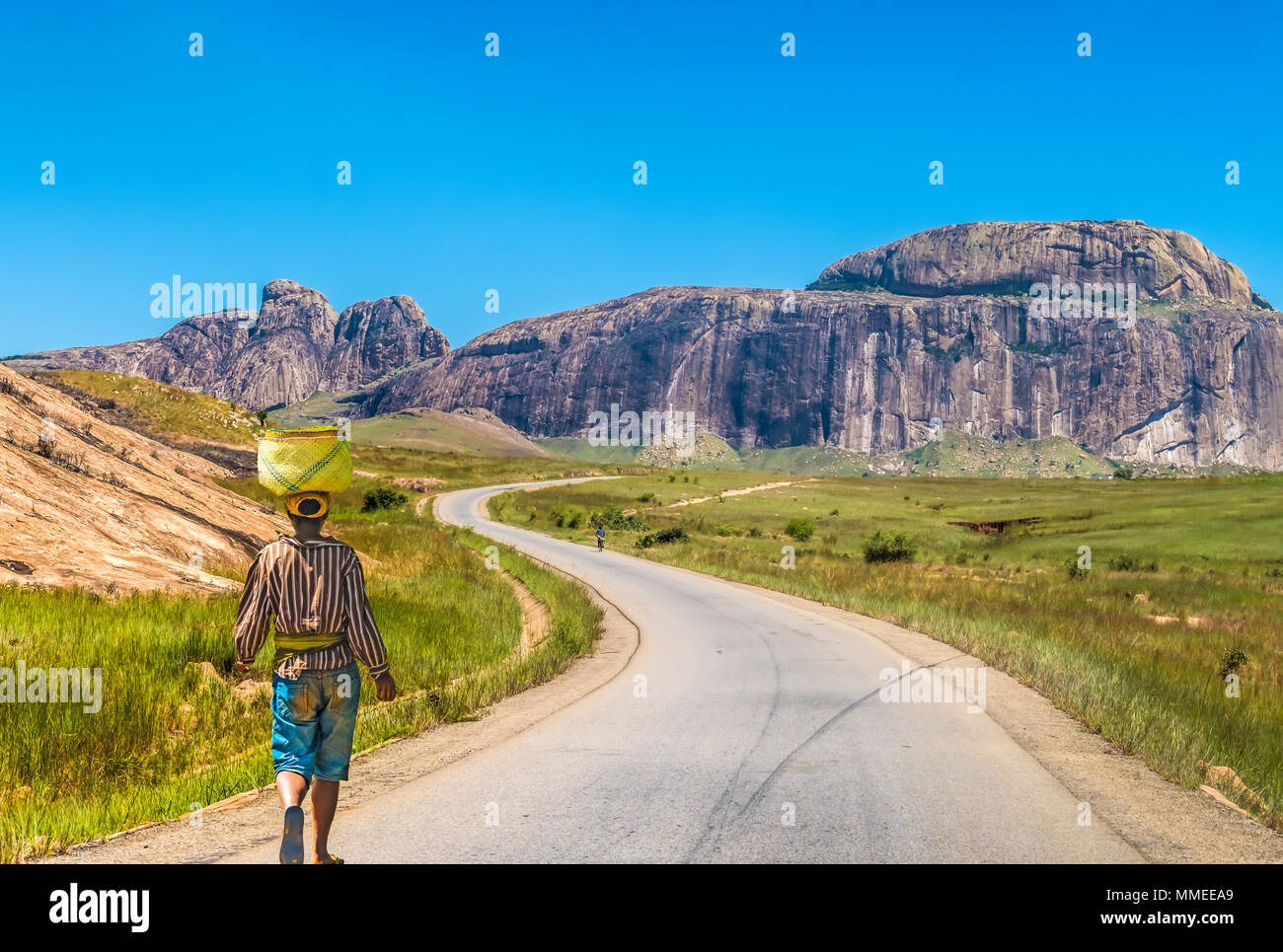 Betsileo people on foot, bicycle or zebu-powered carts on National Route 7 between Ambalavao and Isalo, Madagascar Stock Photo