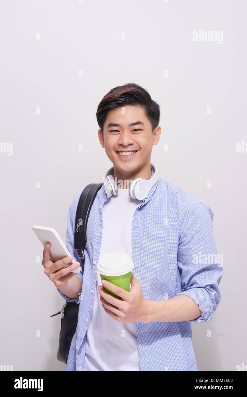 Coffee break. Positive handsome high school student holding a