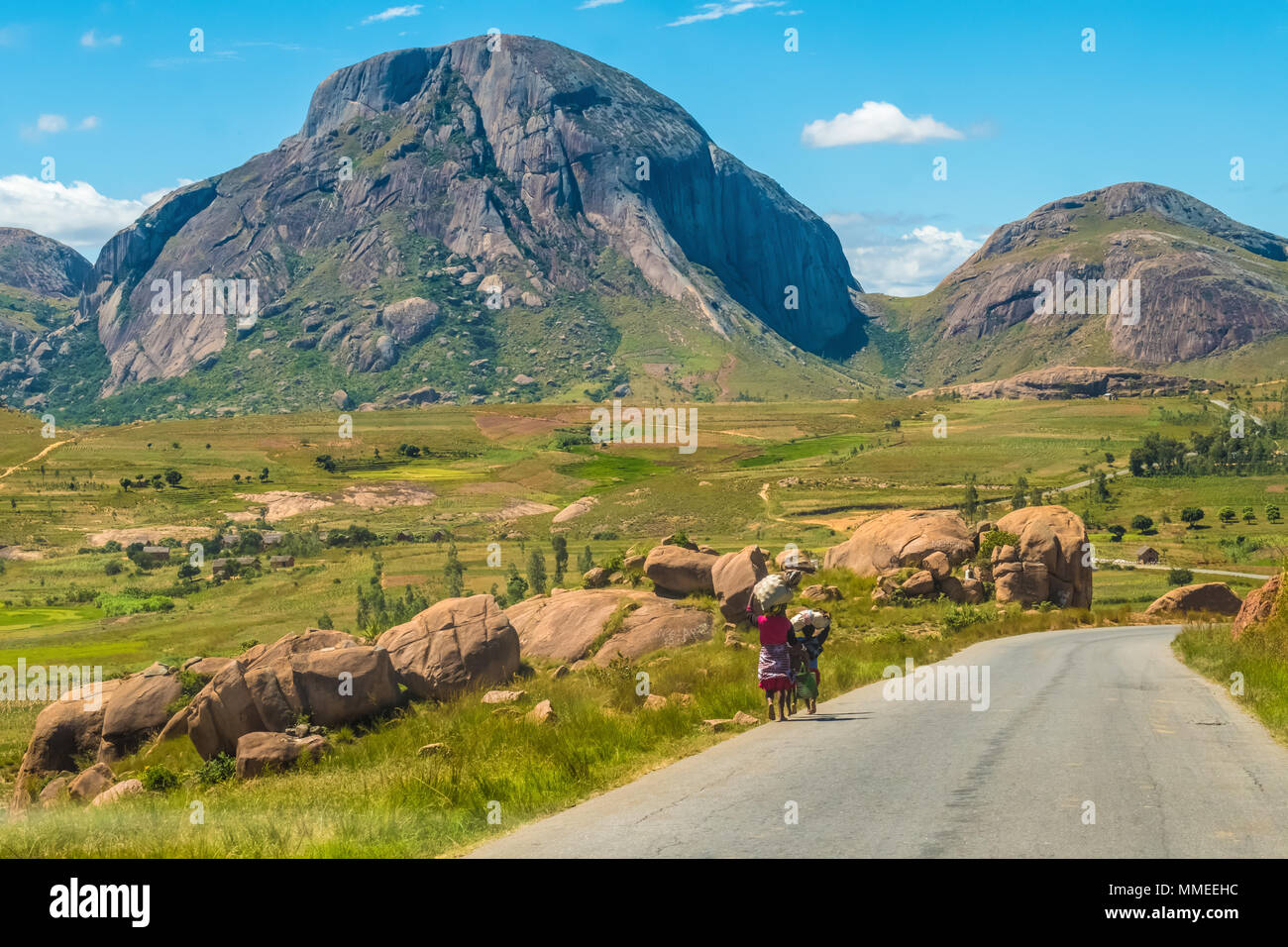 Betsileo people on foot, bicycle or zebu-powered carts on National Route 7 between Ambalavao and Isalo, Madagascar Stock Photo